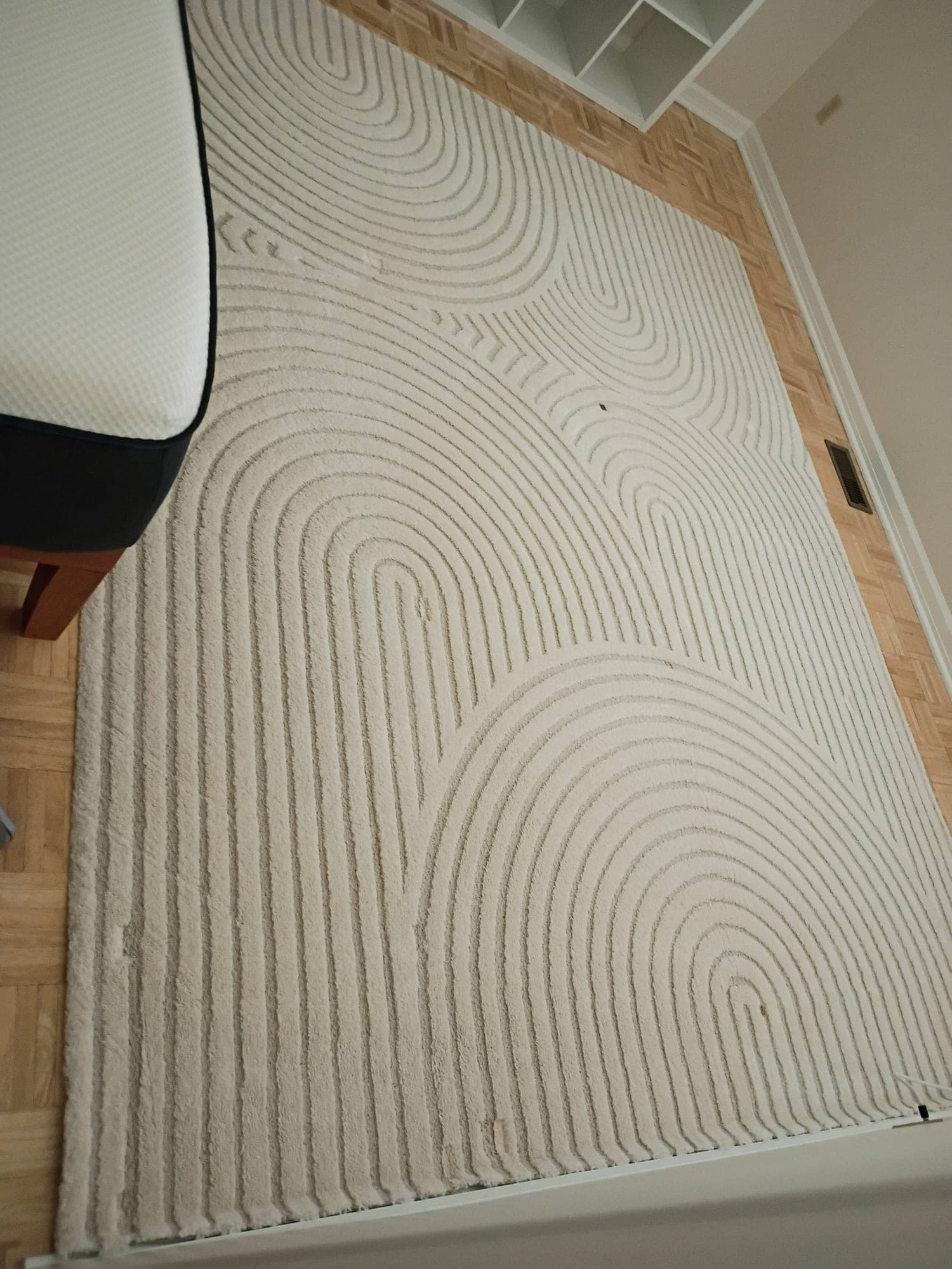 Decorative swirl-pattern area rug freshly cleaned on a parquet floor