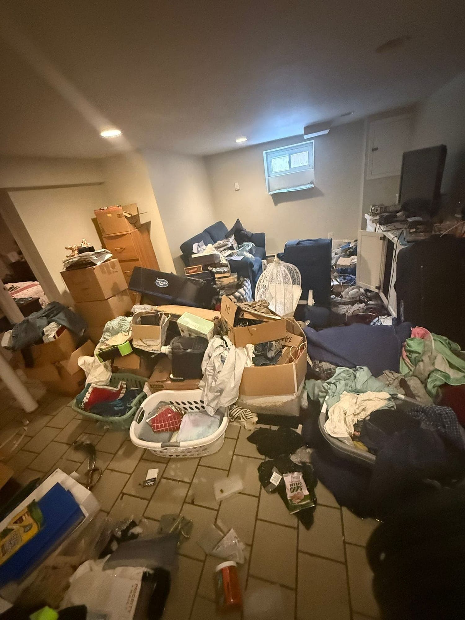 Flooded basement rec room with waterlogged boxes, furniture and soaked contents
