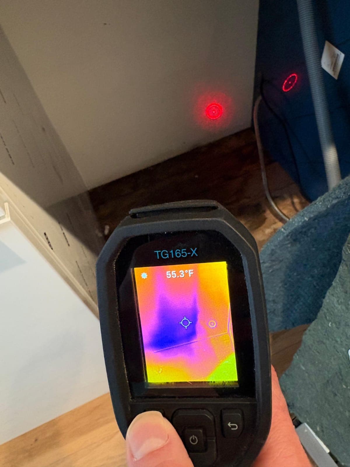 Thermal imaging camera revealing a hidden wet spot at the base of a wall