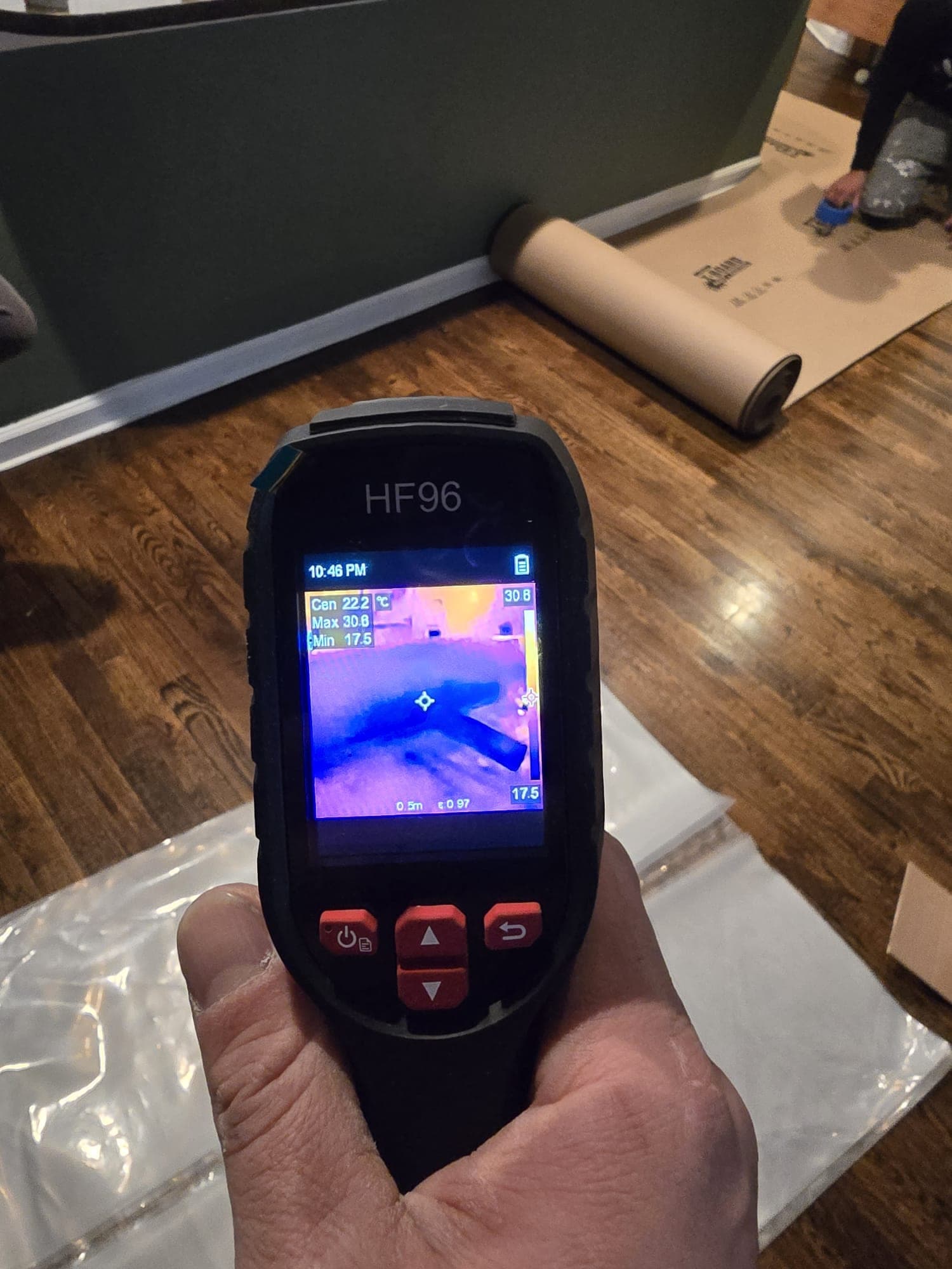 Thermal imaging camera scanning for hidden moisture beneath a hardwood floor